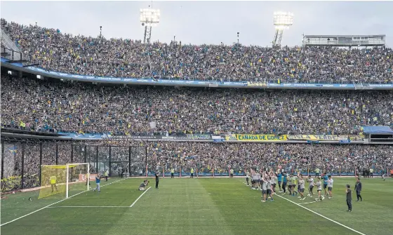  ??  ?? Boca Juniors players applaud their fans during a training session.