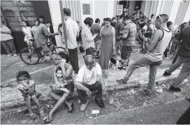  ?? THE ASSOCIATED PRESS ?? People use their devices to communicat­e as they congregate on the street at a wifi hotspot in San Juan, Puerto Rico, in the aftermath of Hurricane Maria. Federal aid is racing to stem a growing humanitari­an crisis in towns left without fresh water,...