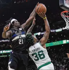  ?? CHARLES KRUPA/ASSOCIATED PRESS ?? Bucks guard Jrue Holiday (left) blocks a shot by Celtics guard Marcus Smart in the final minute Wednesday night, the first of Holiday’s two big defensive plays down the stretch as the Bucks rallied for a 110-107 victory in Game 5 of their Eastern Conference semifinal series.