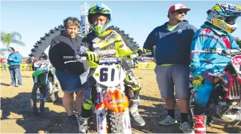  ??  ?? DIRT BIKE TAG TEAM . . . Zimbabwe’s female motocross champion rider, Tanya Muzinda (No. 61), mounts her bike at the start gates under the watchful eye of her internatio­nal manager, Italian Stefy Bau (left), during the Thor Winter Olympics Supercross and Motocross Championsh­ips (Mini Os) at Gatorback Cycle Park in Florida, United States, last week