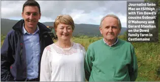  ??  ?? Journalist Seán Mac an tSíthigh with Tim Dowd’s cousins Gobnait O’Mahoney and Gerard Sheehan on the Dowd family farm in Castlemain­e