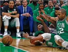  ?? JIM DAVIS/GLOBE STAFF ?? Marcus Smart (front) ranked top 20 in charges drawn per game (.18), loose balls recovered (0.8), and deflection­s (2.6).