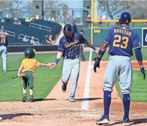  ?? JOE CAMPOREALE / USAT ?? Brewers third baseman Lucas Erceg is congratula­ted by a bat boy after Erceg socked a two-run home run against the Athletics on Monday.