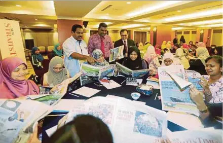  ?? PIC BY ZULKARNAIN AHMAD TAJUDDIN ?? (Standing from left) Johor English Language Teaching Associatio­n president Vincent D’Silva, Johor Baru Education Office English officer Vijayan Narayanan and Grand Bluewave Hotel general manager Long Cheow Siong distributi­ng the newspapers to teachers...