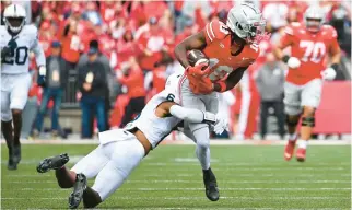  ?? BEN JACKSON/GETTY ?? Ohio State wide receiver Marvin Harrison Jr. makes one of his 11 receptions Saturday as he is tackled by Penn State’s Zakee Wheatley in Columbus, Ohio.