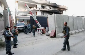  ??  ?? Afghan policemen stand guard outside the Iraqi Embassy after an attack in Kabul on Sunday. (Reuters)