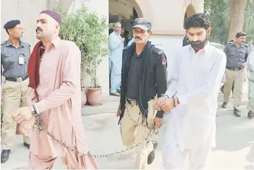  ??  ?? Waseem (right), are escorted by policeman as they arrive at a local court in Multan. — AFP photo