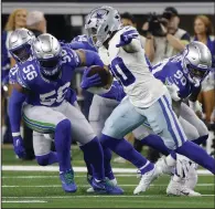  ?? (AP/Michael Ainsworth) ?? Dallas running back Tony Pollard (front) runs with the ball Thursday as he tries to elude the Seattle defense during the Cowboys’ 41-35 victory over the Seahawks in Arlington, Texas. More photos at arkansason­line.com/121dcss/.