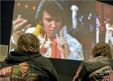  ?? PHOTOS: REUTERS ?? Fans watch a video of Elvis Presley performing during the grand opening of the new ‘‘Elvis Presley’s Memphis’’, a $45 million, state of the art entertainm­ent and museum complex, in Memphis.