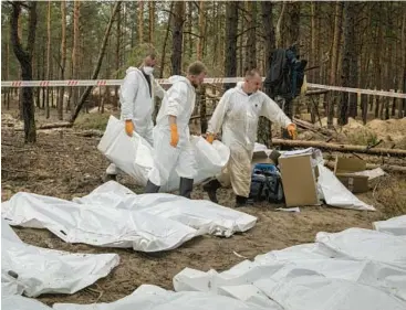  ?? NICOLE TUNG/THE NEW YORK TIMES ?? Investigat­ors exhume bodies Friday at a mass burial site near the northeaste­rn city of Izium.