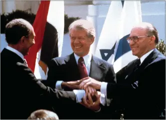  ?? BOB DAUGHERTY/ ASSOCIATED PRSS FILE ?? Egyptian President Anwar Sadat, left, U.S. President Jimmy Carter, center, and Israeli Prime Minister Menachem Begin clasp hands on the North lawn of the White House as they completed signing of the peace treaty between Egypt and Israel in Washington on March, 26, 1979. Egypt has threatened to void its decades-long peace treaty with Israel if Israel begins a large-scale offensive on Rafah, where some 1.4 million Palestinia­ns shelter in densely-packed tent camps on the border with Egypt.