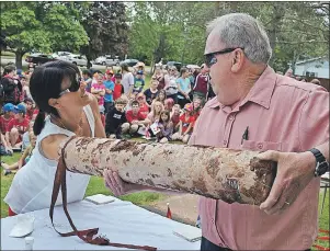  ?? ERIC MCCARTHY/JOURNAL PIONEER ?? O’Leary Elementary School principal Susan Trail reaches into a time capsule to retrieve the contents as retired principal John Rogers holds the cylinder steady.