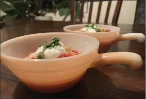  ?? (Tracee Herbaugh via AP) ?? Two vintage peach lustre Fire-King chili bowls sit atop a table. There are lustrous chili bowls with handles, stackable refrigerat­or boxes, and casserole dishes set on top of brass candle warmers. These are durable dishes, often smaller than modern serving pieces, that can go from freezer to oven to table. But collectors usually acquire them for enjoyment, not utility.