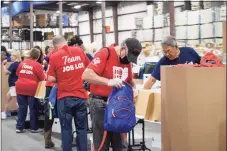  ?? Ocean State Job Lot / Contribute­d photo ?? Representa­tives from Ocean State Job Lot help stuff backpacks with donated school supplies in Foxborough, Mass.
