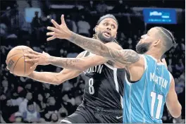  ?? JOHN MINCHILLO — THE ASSOCIATED PRESS ?? Brooklyn Nets guard Patty Mills (8) looks to pass against Charlotte Hornets forward Cody Martin (11) during the second half Sunday in New York.