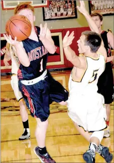  ?? PHOTO BY RICK PECK ?? McDonald County’s Blake Gravette gets hip-checked by Cassville’s Austin Wilson as he drives to the basket during the Mustangs’ 47-43 win on Tuesday night at MCHS.