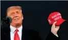  ?? Photograph: Alex Edelman/AFP/Getty Images ?? Donald Trump holds up a MAGA hat as he speaks during a campaign event at Des Moines Internatio­nal Airport in Iowa.