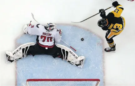  ?? JUSTIN K. ALLER/GETTY IMAGES ?? Nick Bonino of the Penguins scores his game-winning goal 6:30 into OT against the Capitals on Tuesday night.