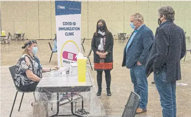  ?? FRANK GUNN THE CANADIAN PRESS FILE PHOTO ?? Toronto nurse Amanda Alves, seated, greets Premier Doug Ford, centre, and Toronto Mayor John Tory during a tour of Toronto’s mass vaccinatio­n clinic with Dr. Eileen de Villa. Many Ontario doctors feel uninformed about the vaccine rollout.