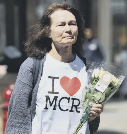  ?? PICTURE: JEFF MITCHELL/GETTY ?? 0 A woman wearing an ‘I heart MCR’ T-shirt makes her way to lay flowers in St Ann Square