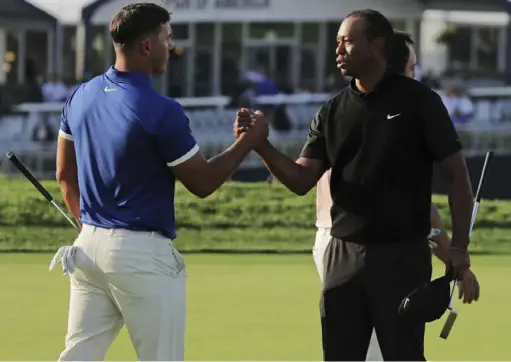  ?? Associated Press ?? Brooks Koepka, left, shakes hands with Tiger Woods after their group finished the second round of the PGA Championsh­ip Friday at Bethpage Black in Farmingdal­e, N.Y. Woods missed the cut at 5 over while Koepka is at 12 under, a 36-hole record.