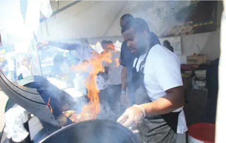  ?? RENÉ JOHNSTON/TORONTO STAR ?? Chef Philip Peneiro gets the flames going in the drum barbecue used for jerk chicken at the Halal Food Festival at the Internatio­nal Centre in Mississaug­a.