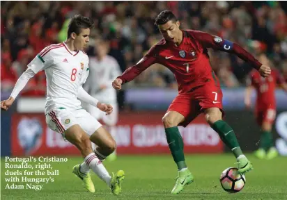  ??  ?? Portugal's Cristiano Ronaldo, right, duels for the ball with Hungary's Adam Nagy