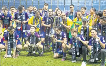  ??  ?? LEFT
Port players and officials pose with the FA Cup trophy.