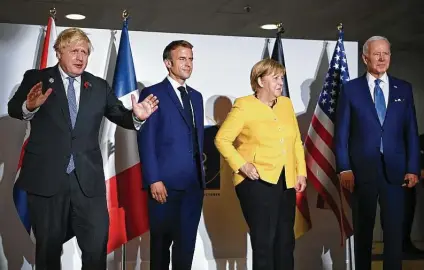  ?? Jeff J. Mitchell / Associated Press ?? British Prime Minister Boris Johnson, left, French President Emmanuel Macron, German Chancellor Angela Merkel and President Joe Biden meet Saturday at the two-day G20 summit in Rome, the first in-person gathering since the COVID-19 pandemic started.