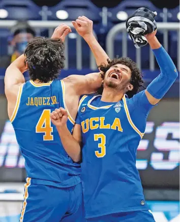  ?? MICHAEL CONROY/ASSOCIATED PRESS ?? UCLA’s Jaime Jaquez Jr., left, and Johnny Juzang celebrate after beating Alabama 88-78 in overtime in the NCAA Tournament’s Sweet 16 on Sunday in Indianapol­is.