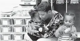  ?? KIM HAIRSTON/BALTIMORE SUN ?? Chardai Elliott, 2, hugs Imani Sims, teacher's aide, goodbye as Jeremiah Hilton, 2, plays with a toy during a visit to a Loyola Early Learning Center classroom.