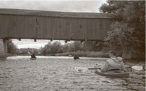  ?? Submitted ?? Participan­ts from last year’s Grand Kayak event pass under the covered bridge in West Montrose.