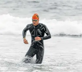  ?? Picture: WERNER HILLS ?? COOL CUSTOMER: Keegan Cooke emerges in first position from the swim leg of the Nelson Mandela Bay Triathlon Championsh­ips at Pollok beach on his way to winning the title