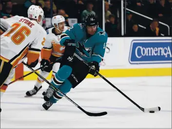  ?? PHOTOS BY NHAT V. MEYER — BAY AREA NEWS GROUP FILE ?? The San Jose Sharks’ Patrick Marleau (12) controls the puck against the Calgary Flames’ Michael Stone (26) in the third period at the SAP Center in San Jose on Feb. 10.