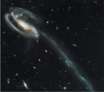  ?? NASA VIA THE ASSOCIATED PRESS ?? This picture of the galaxy UGC 10214 was taken in 1995 by the Advanced Camera for Surveys, which was installed aboard NASA’S Hubble Space Telescope in during Servicing Mission 3B. Dubbed the “Tadpole,” this spiral galaxy is unlike the textbook images of stately galaxies. Its distorted shape was caused by a small interloper, a very blue, compact galaxy visible in the upper left corner of the more massive. Tadpole. The Tadpole resides about 420 millionlig­ht-years away in the constellat­ion Draco.