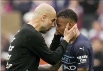  ?? KIRSTY WIGGLESWOR­TH — THE ASSOCIATED PRESS ?? Manchester City’s head coach Pep Guardiola, left, interacts with player Gabriel Jesus at the end of the English Premier League soccer match between West Ham United and Manchester City in London last Sunday.