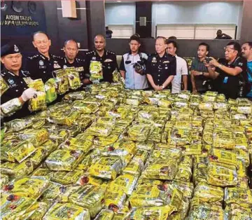  ?? PIC BY RAMDZAN MASIAM ?? Federal Narcotics Crime Investigat­ion Department director Datuk Seri Mohmad Salleh (left) showing the ‘syabu’ in Chinese tea packaging at the state police contingent headquarte­rs in George Town yesterday.