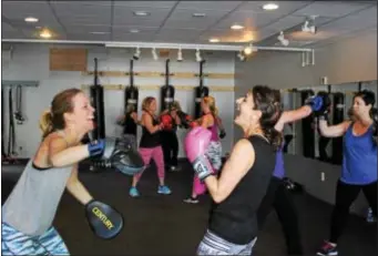  ?? MICHILEA PATTERSON — DIGITAL FIRST MEDIA ?? Lori Knight, left, and Marie Paone share a laugh during a boxing bootcamp class at the Ignite Fitness Studio in West Vincent. Paone said the cardio-intensive activity motivates her to take all the rest of the week.