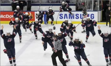  ?? JASON KRYK — THE ASSOCIATED PRESS ?? U.S. players begin to celebrate after Hillary Knight scored in overtime for a 3-2 victory over Canada in the gold-medal game of the women’s hockey world championsh­ips in Plymouth, Mich. on Friday.