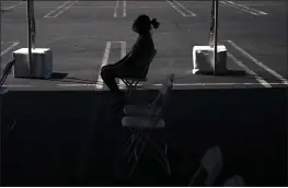  ?? JAE C. HONG — THE ASSOCIATED PRESS FILE ?? A woman sits in the waiting area after receiving the COVID-19vaccine at a clinic set up in the parking lot of CalOptima in Orange.