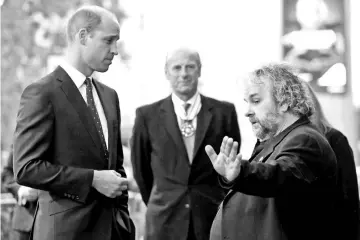  ?? — Reuters photos ?? Britain’s Prince William, Duke of Cambridge speaks with New Zealand film maker Peter Jackson as he attends the world premiere of Peter Jackson’s film “They Shall Not Grow Old” during the BFI London Film Festival in London, Britain Oct 16 • (above right) Jackson arrives for the world premiere of his film and Prince William speaks with Diane Lees, director-general of Imperial War Museums and commission­ers and producers of “14-18 Now” as he attends the world premiere.