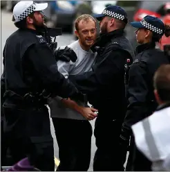  ??  ?? SWOOP: Police detain a man outside the activists’ London base