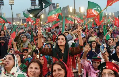  ?? AFP ?? supporters gesture and wave flags of the Pakistan tehreek-e-Insaf party as they attend the rally in Lahore. —