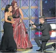  ??  ?? Debra Messing (C) and Chris Hardwick present the award for Outstandin­g Lead Actress in a Comedy Series to Julia Louis Dreyfus (L) for Veep