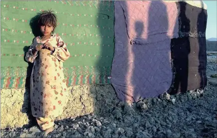  ?? PICTURES: REUTERS AND AP ?? PAKISTAN: Shafia Helmand stands next to a tent near shadows cast by fellow Afghan refugees, in Quetta, in this photograph from the Pulitzer Prizewinni­ng entry in feature photograph­y awarded to the staff of The New York Times.