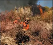  ?? NOAH BERGER — THE ASSOCIATED PRESS ?? An inmate firefighte­r creates a fire break as the Maria Fire approaches in Santa Paula on Friday.