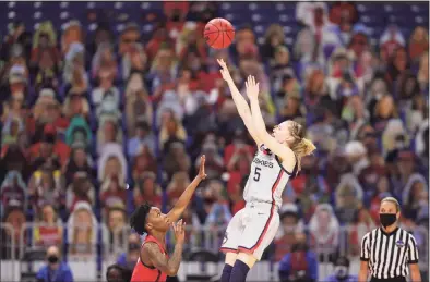  ?? Carmen Mandato / Getty Images ?? Paige Bueckers, of the UConn Huskies, center, shoots over Shaina Pellington of the Arizona Wildcats during the second quarter in the Final Four semifinal game of the 2021 NCAA Women’s Basketball Tournament at the Alamodome on Friday in San Antonio, Texas.