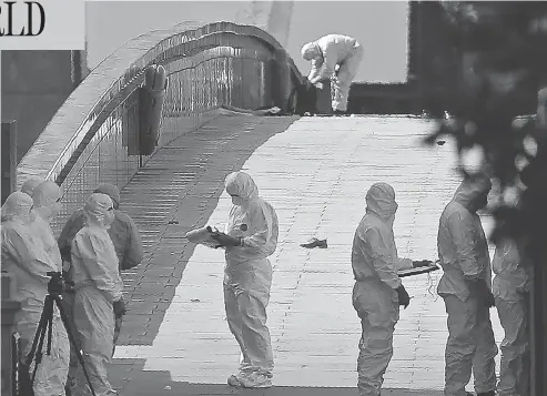  ?? DANIEL LEAL-OLIVAS / AFP / GETTY IMAGES ?? Forensic officers continue their investigat­ions on London Bridge Sunday following Saturday’s terror attack that killed seven and injured dozens.