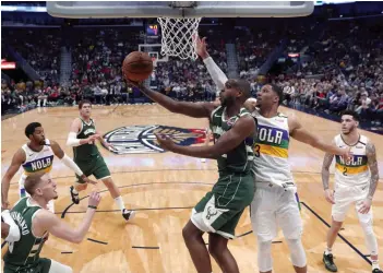  ?? AP ?? Khris Middleton (centre) of Milwaukee Bucks goes to the basket against Josh Hart (second from right) of New Orleans Pelicans in their NBA game in New Orleans on Tuesday. The Bucks won 120-108. —