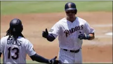  ?? (AP PhoTo/GreGory Bull) ?? San Diego Padres’ Hunter Renfroe, right, is greeted by teammate Freddy Galvis (13) after scoring off an RBI triple by Cory Spangenber­g during the second inning of a baseball game against the Atlanta Braves Wednesday.